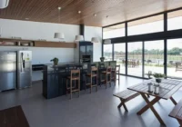 Área gourmet com cozinha, churrasqueira e vista para campo de futebol — Alphaville Pelotas
