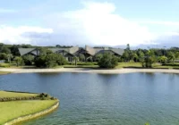 Lagoa com areia e paisagismo em frente ao clube do condomínio — Bosques de Atlântida