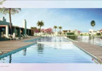 Piscina e área de lazer com bangalôs e casas ao fundo — laranjal