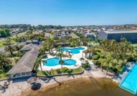 Vista aérea do condomínio com piscinas, lago e casas ao redor — Atlântida Ilhas Park