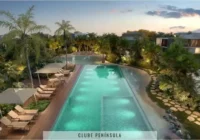 Piscina com área de lazer e paisagismo exuberante ao entardecer — Condomínio Raro