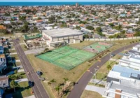 Vista aérea do condomínio Riviera com quadras esportivas e casas modernas
