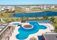 Vista aérea do condomínio Riviera com piscinas e lago