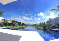 Piscina com vista para o canal e casas do condomínio — Malibu Beach Residence