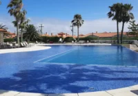 Ampla piscina externa com área de lazer e espreguiçadeiras no condomínio — Condomínio Casa Hermosa