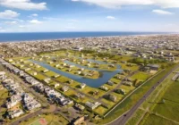 Vista aérea do condomínio fechado com lagos artificiais e mar ao fundo — Condomínio Enseada Lagos de Xangri-Lá